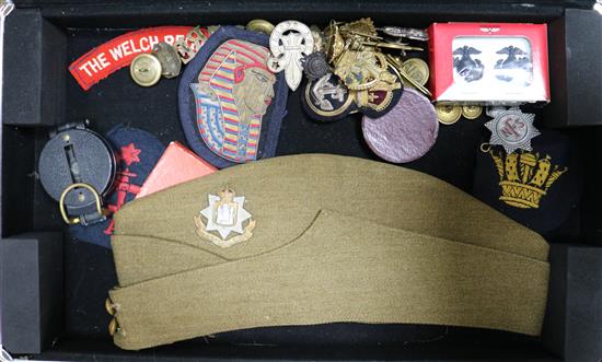 A collection of British military cap badges, buttons, etc.